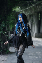 Person with blue hair wearing a black bodysuit in an outdoor setting