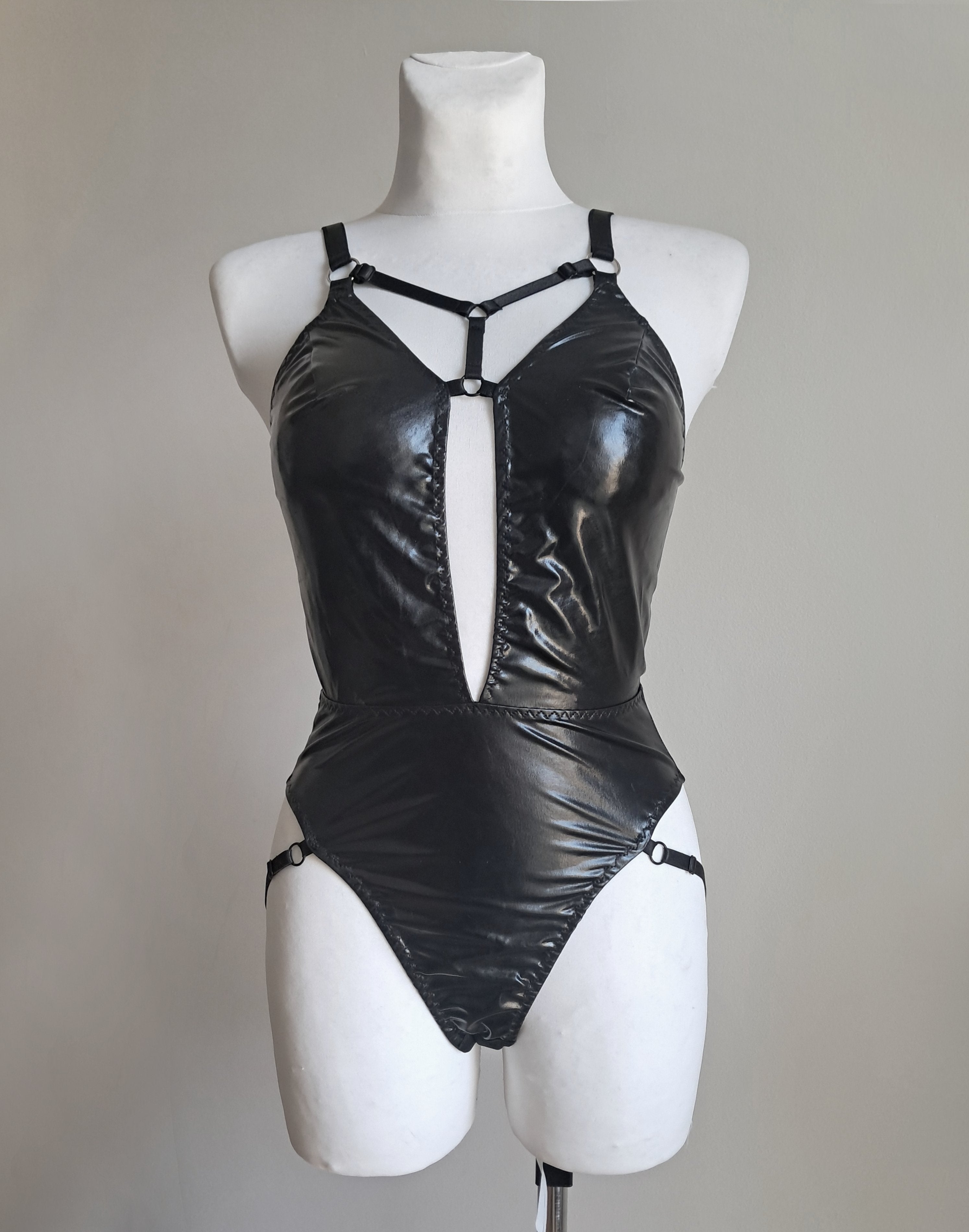 Black gothic bodysuit on a mannequin against a plain background