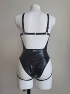 Black gothic bodysuit on a mannequin against a plain background