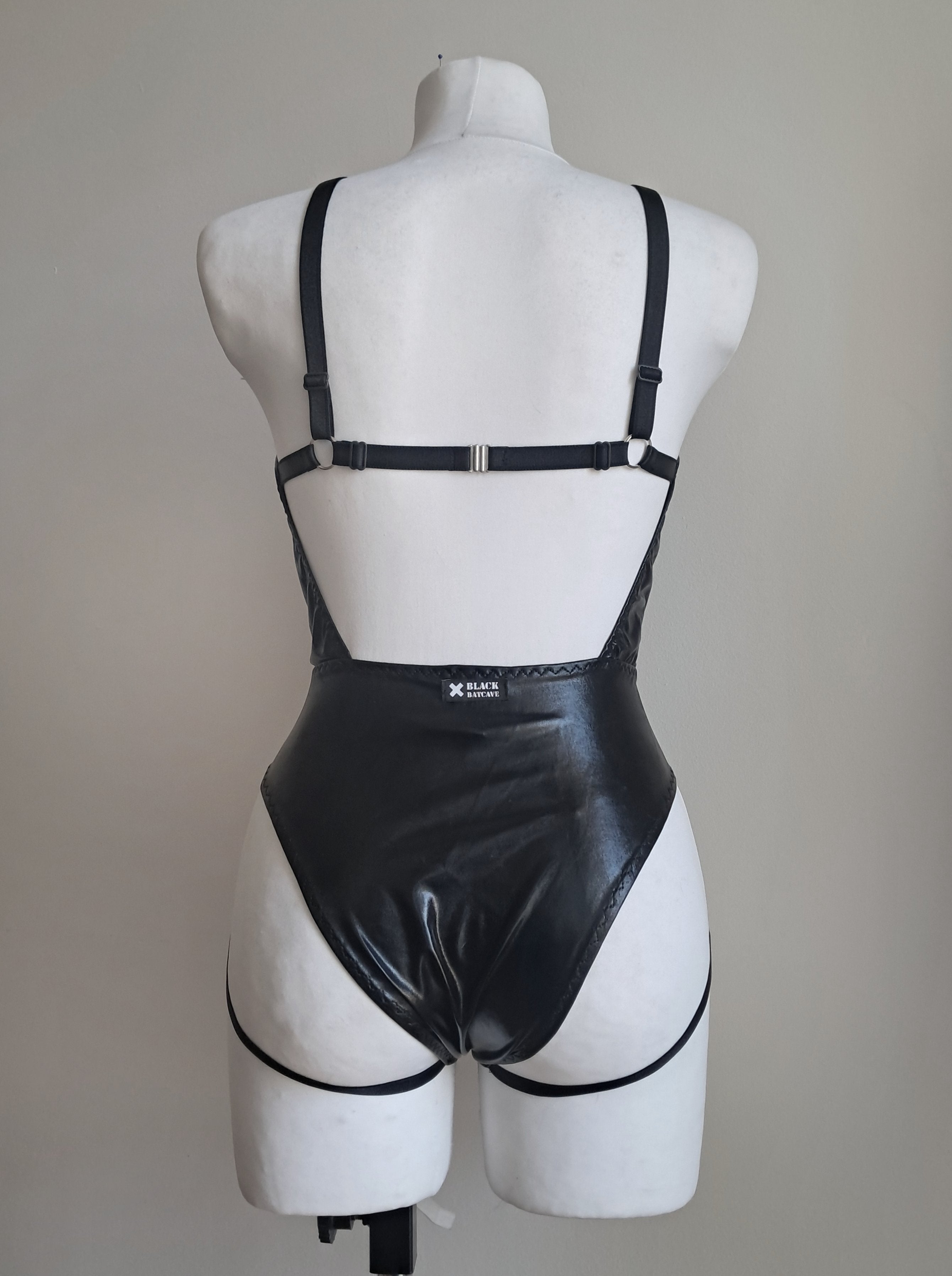 Black gothic bodysuit on a mannequin against a plain background