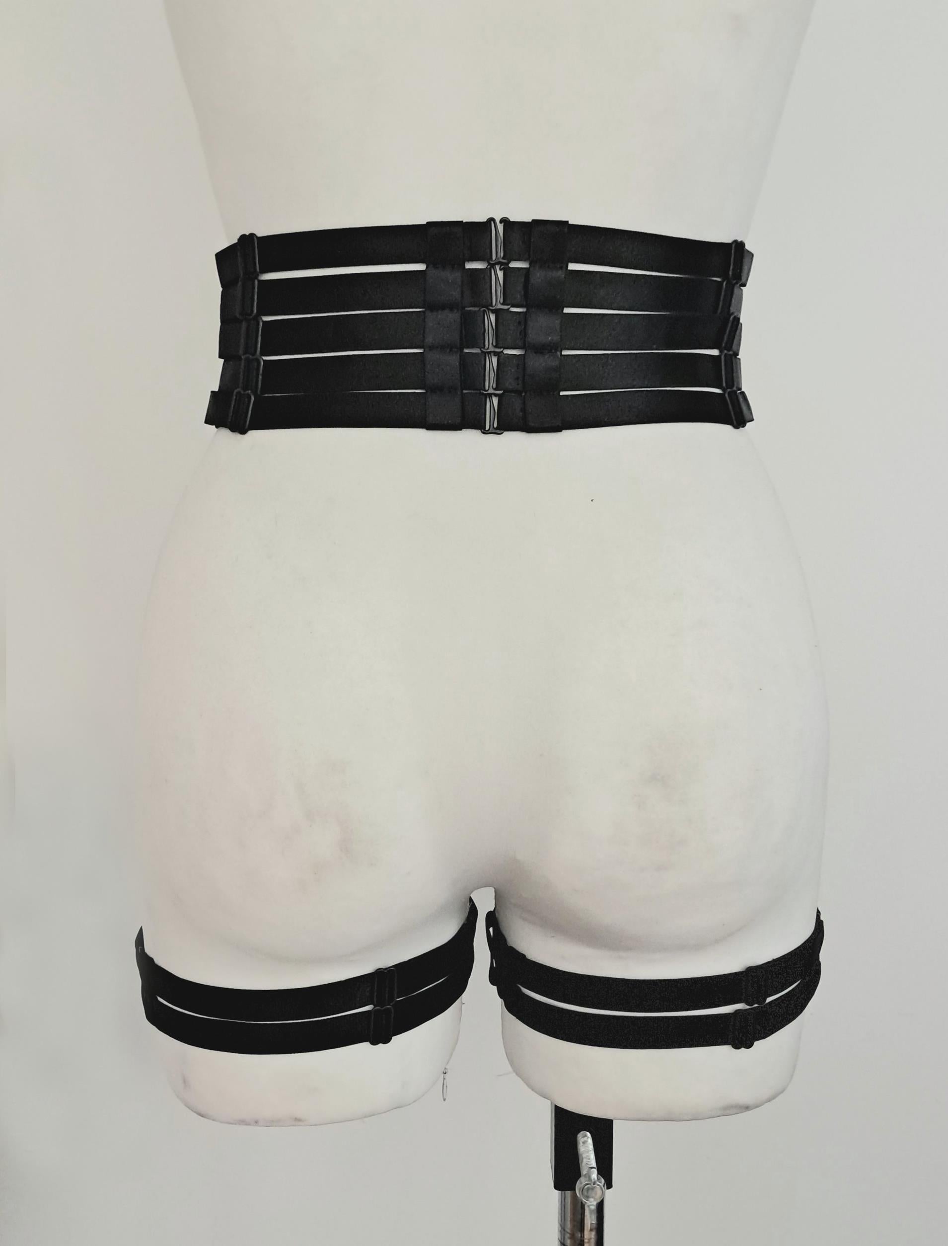 Black satin shine strappy garter belt on a mannequin against a white background