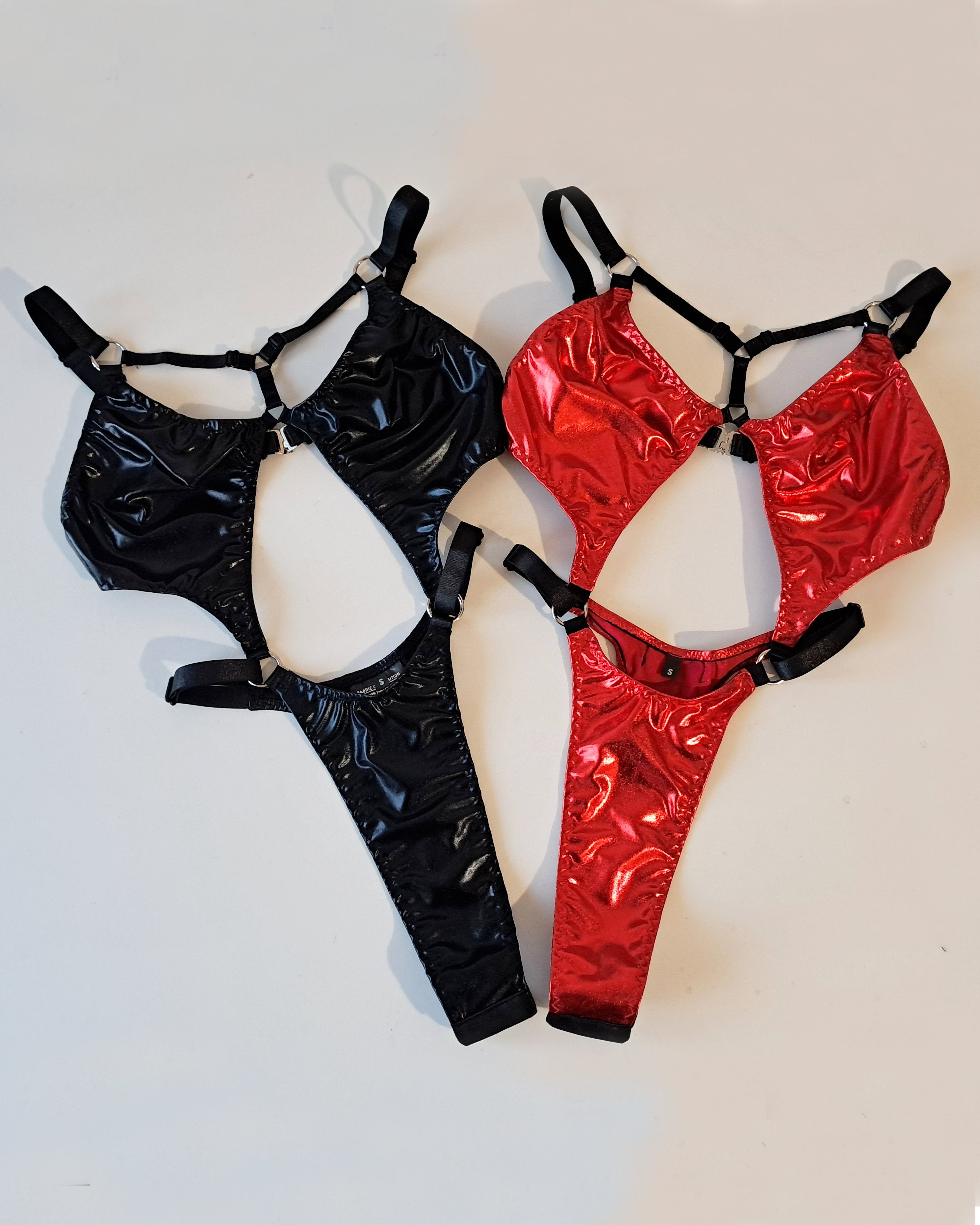 Black and red shiny bodysuits on a white background