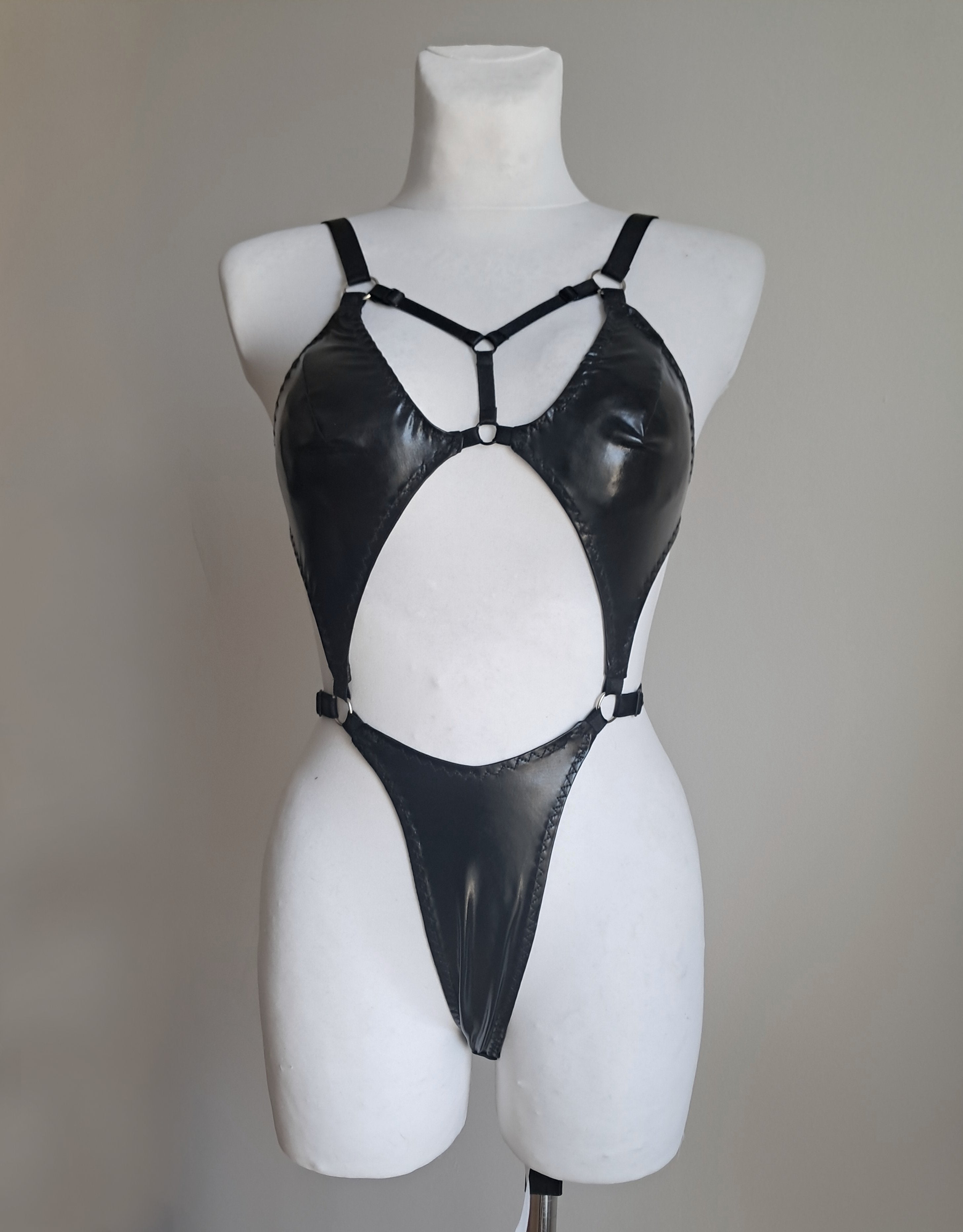 Black bodysuit on a mannequin against a plain background