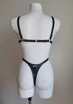 Black bodysuit set on a mannequin against a plain background