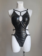 Black shiny bodysuit  on a mannequin against a plain background