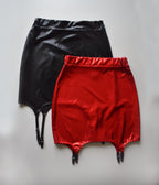 Black and red wet look mini skirt with suspenders on a light gray background