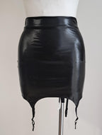 Black wet look mini skirt with suspenders on a mannequin against a plain background