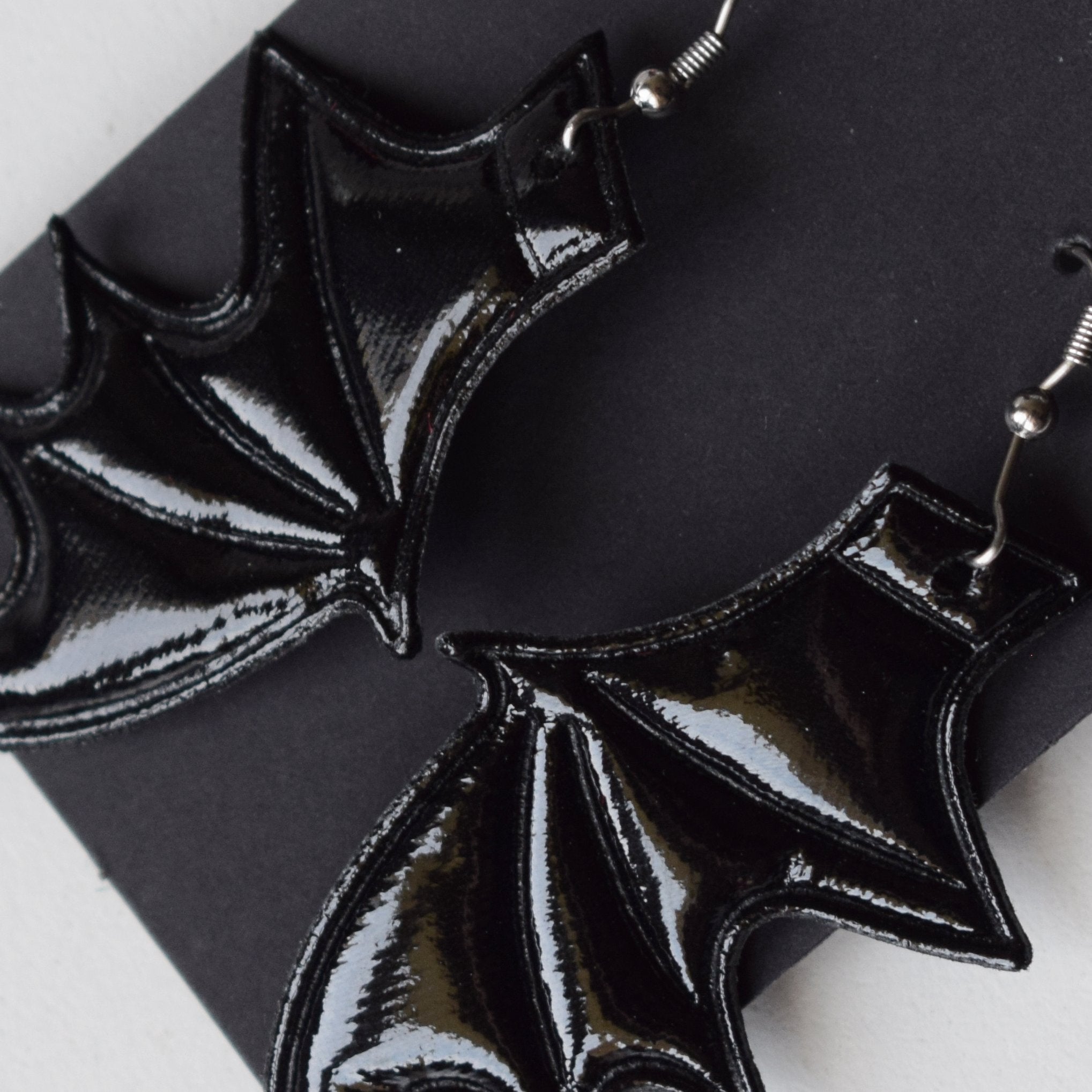 Black bat-wing earrings on a black background