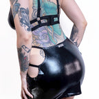 Person wearing a black wet-look cut-out mini skirt on a white background