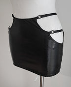 Black wet-look cut-out mini skirt on a mannequin against a gray background