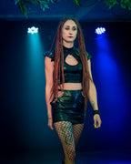 Woman in a wet-look cut-out mini skirt  with fishnet stockings against a blue background