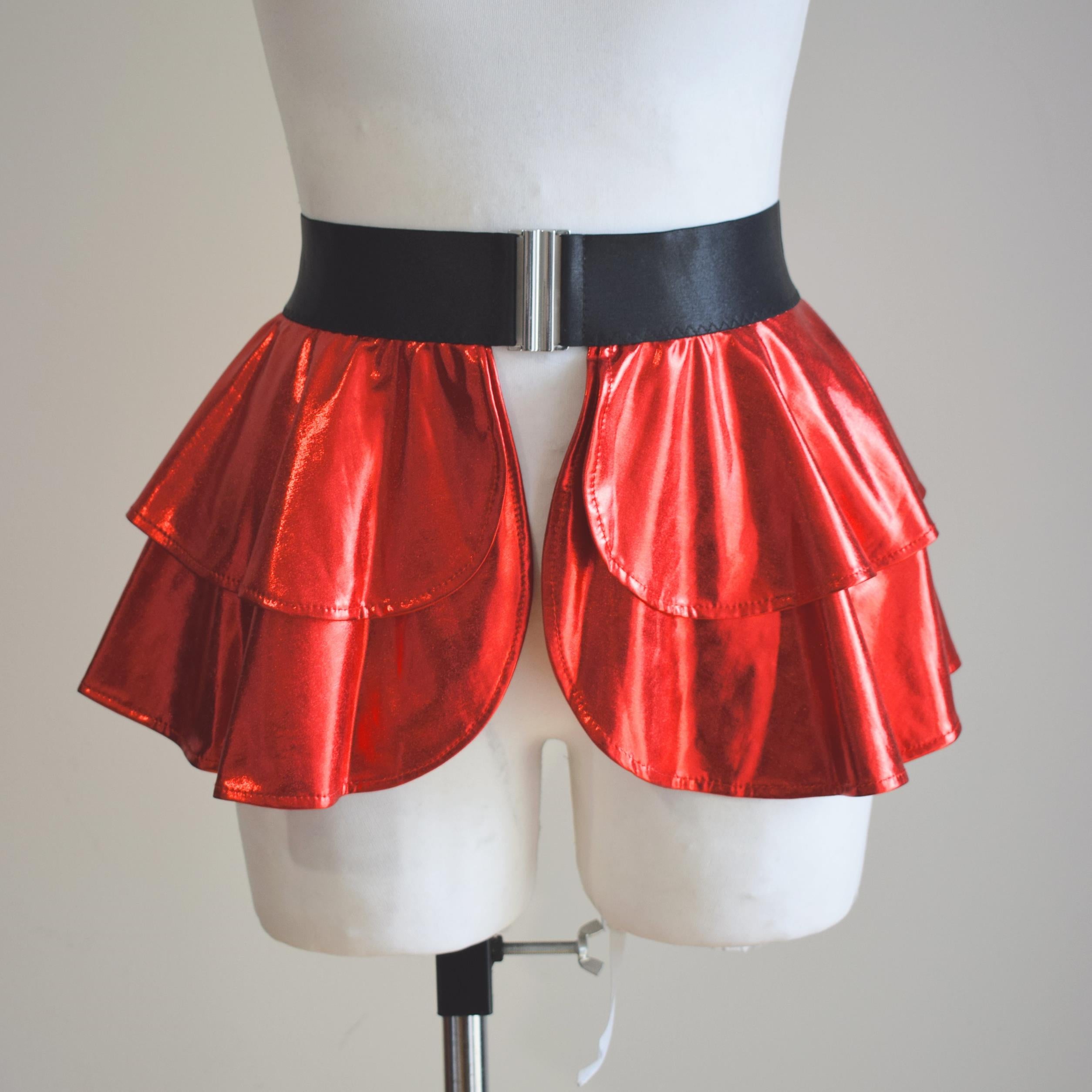 Red wet-look open front mini skirt on a mannequin with a black belt against a plain background