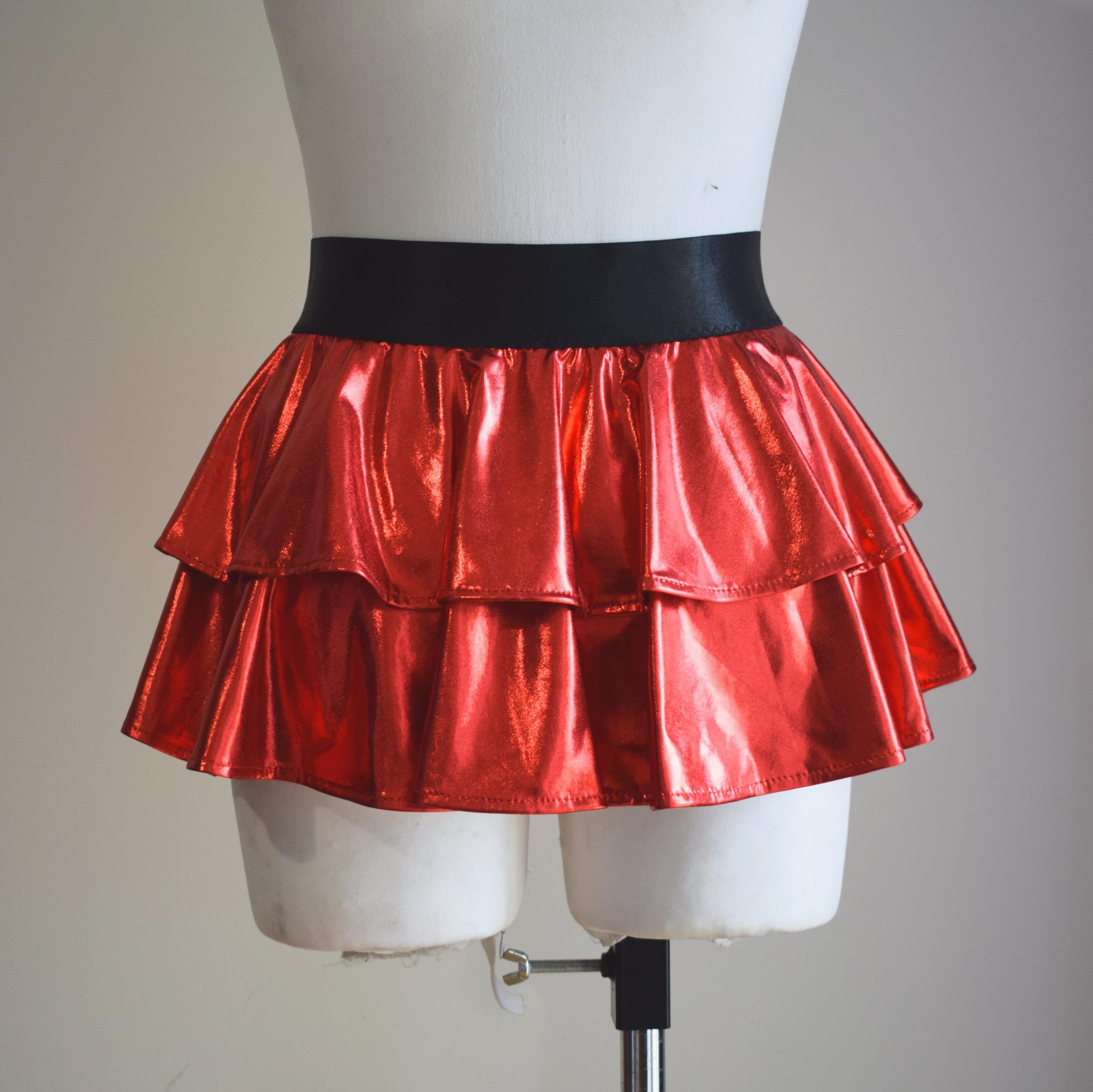Red wet-look open front mini skirt on a mannequin against a plain background