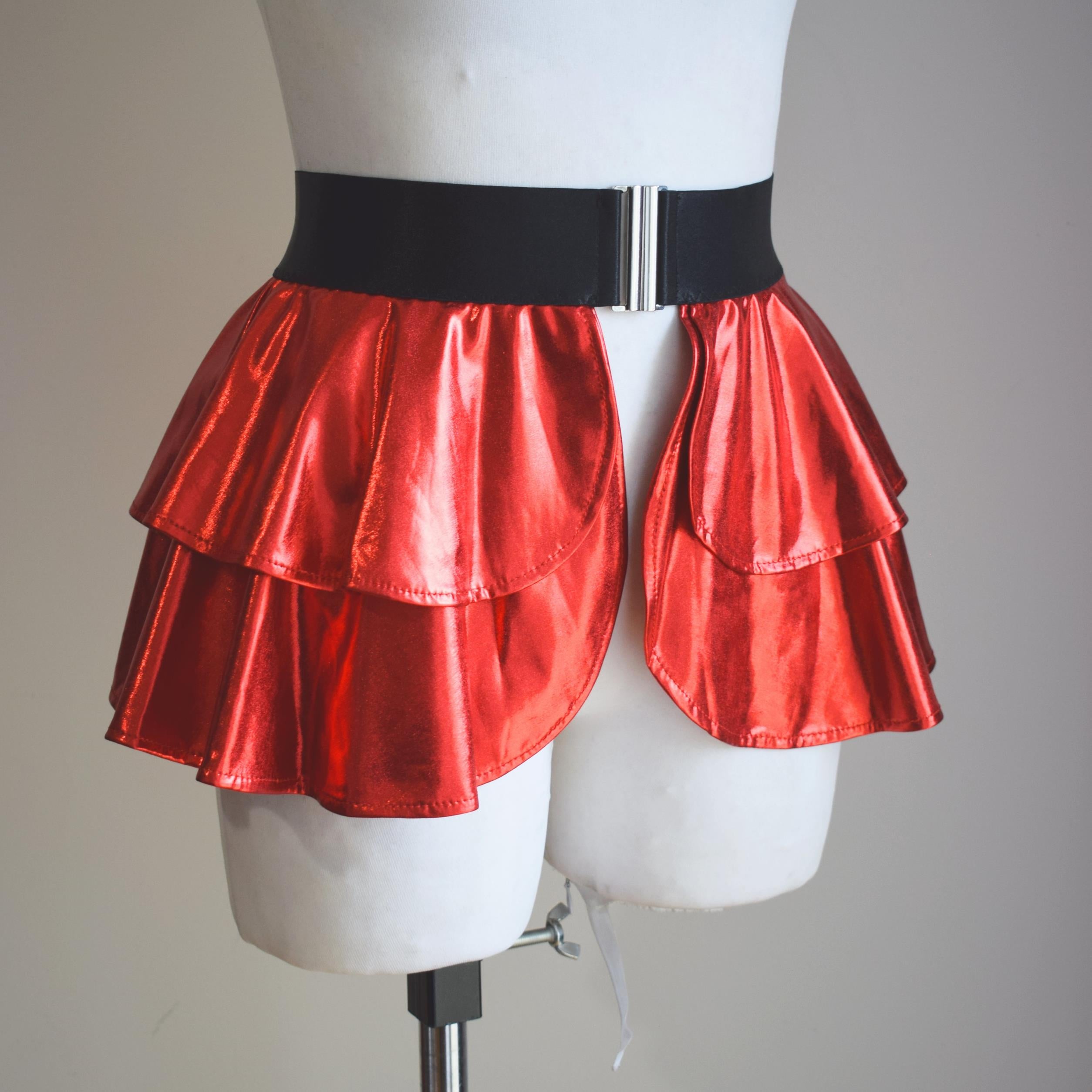 Red wet-look open front mini skirt on a mannequin with a black belt against a plain background