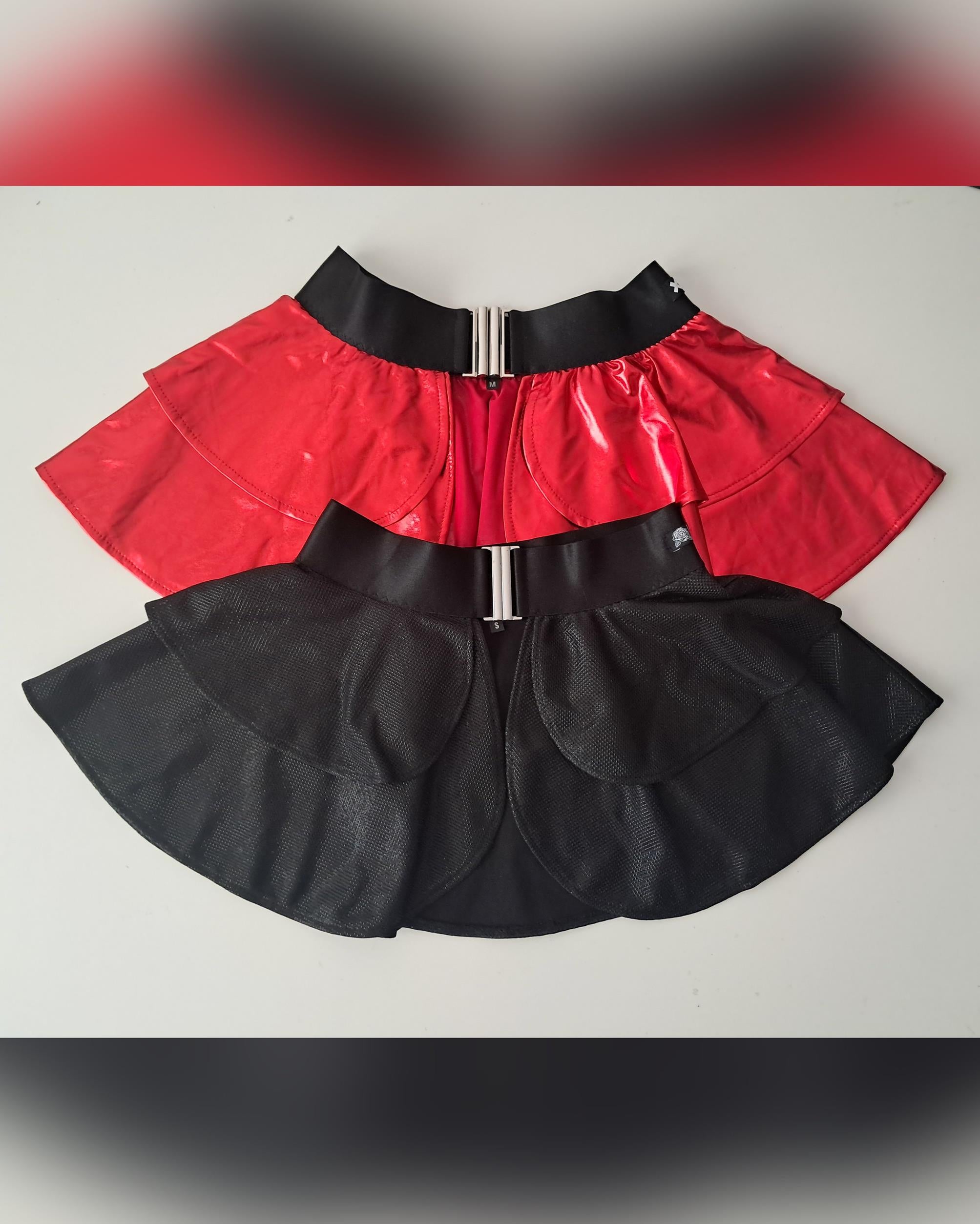 Red top and black wet-look open front mini skirts on a light gray background
