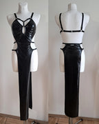 Black wet look dress on a mannequin with cut-out design against a plain background