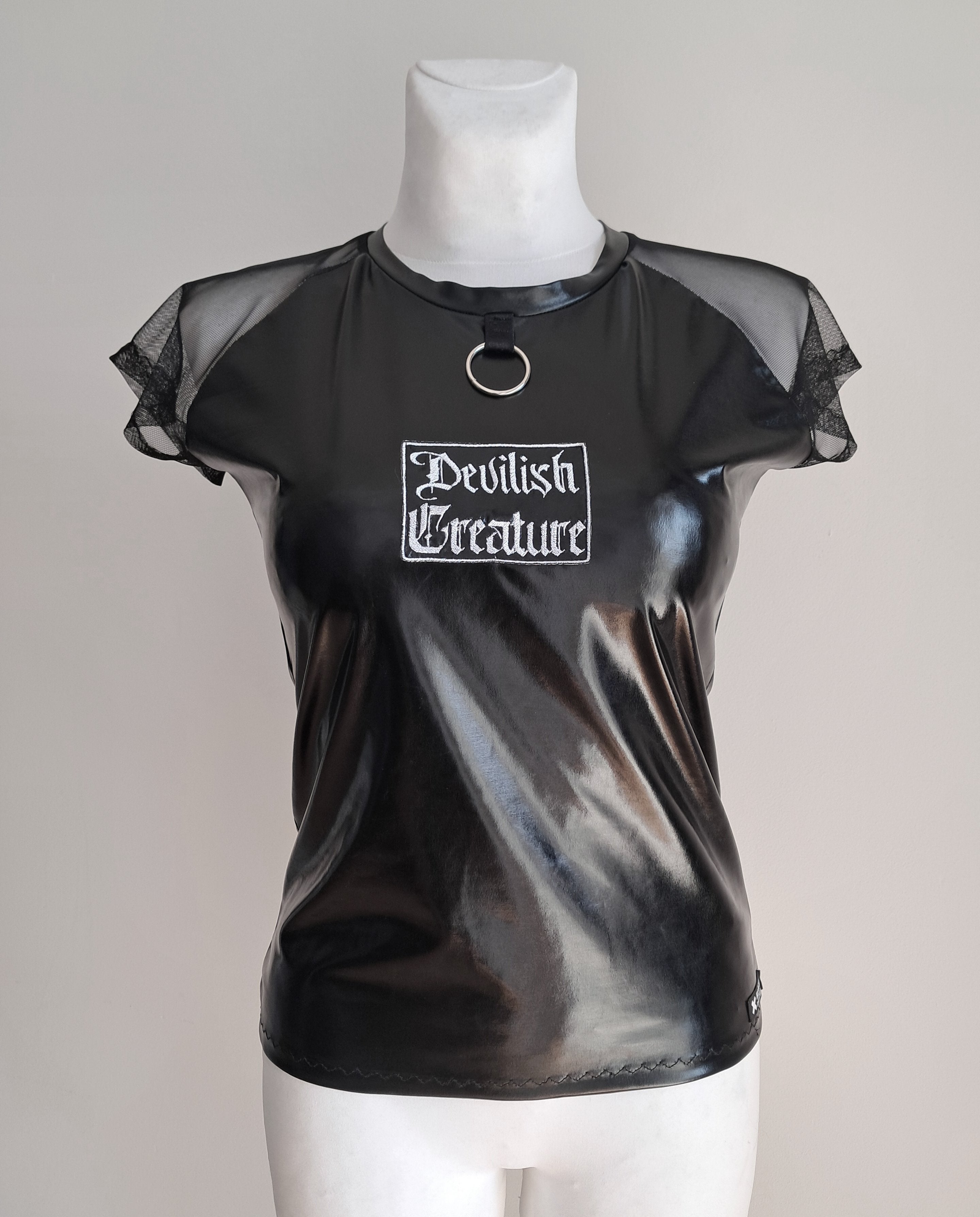 Black wet-look mesh sleeve t-shirt with 'Devilish Creature' text on a mannequin against a gray background
