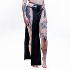 Person wearing a black wet-look cut-out maxi skirt with high slits on a white background