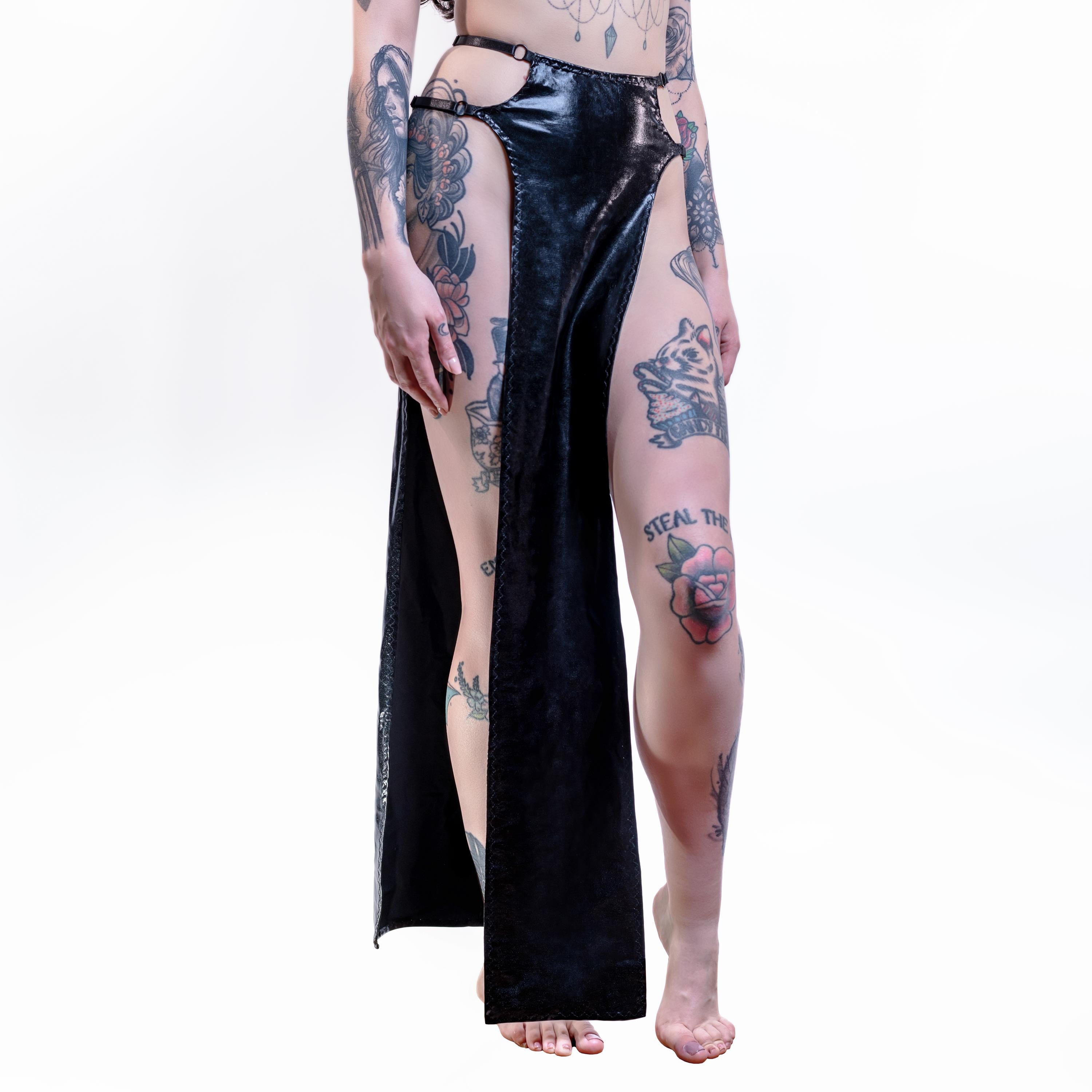 Person wearing a black wet-look cut-out maxi skirt with high slits on a white background