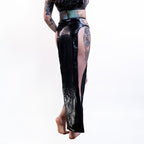 Black wet-look cut-out maxi skirt with sheer panels worn by a person on a white background