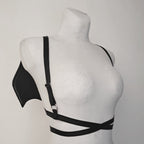 Black harness with bat wings on a mannequin against a gray background