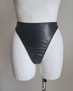 Black wet look high waist thong on a mannequin against a plain background