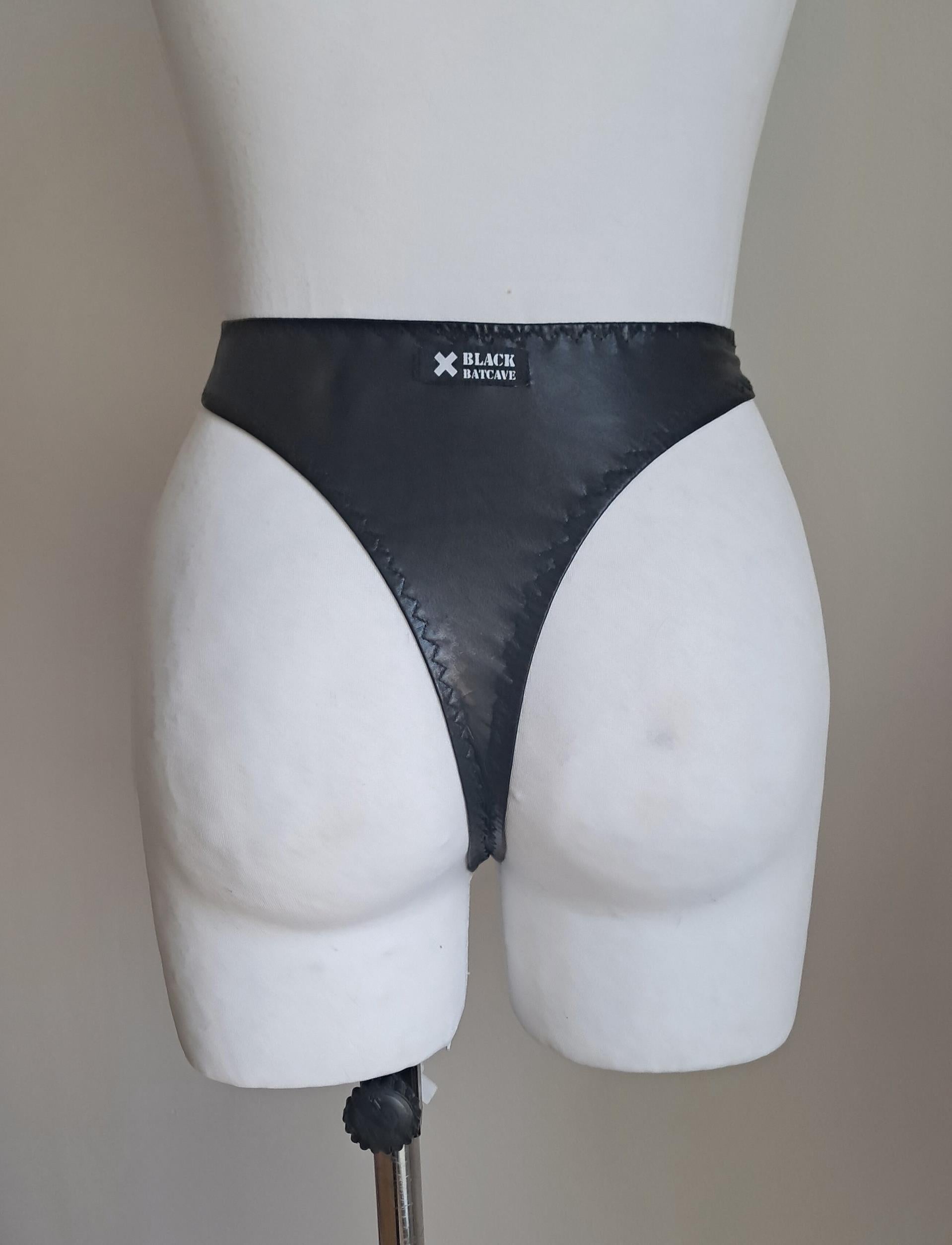 Black wet look high waist thong on a mannequin against a plain background