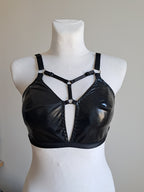 Black wet look bra  on a mannequin bust against a neutral background