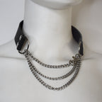 Black leather collar with silver chain on a mannequin neck.