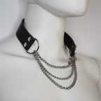 Black leather choker with silver chains on a mannequin neck.