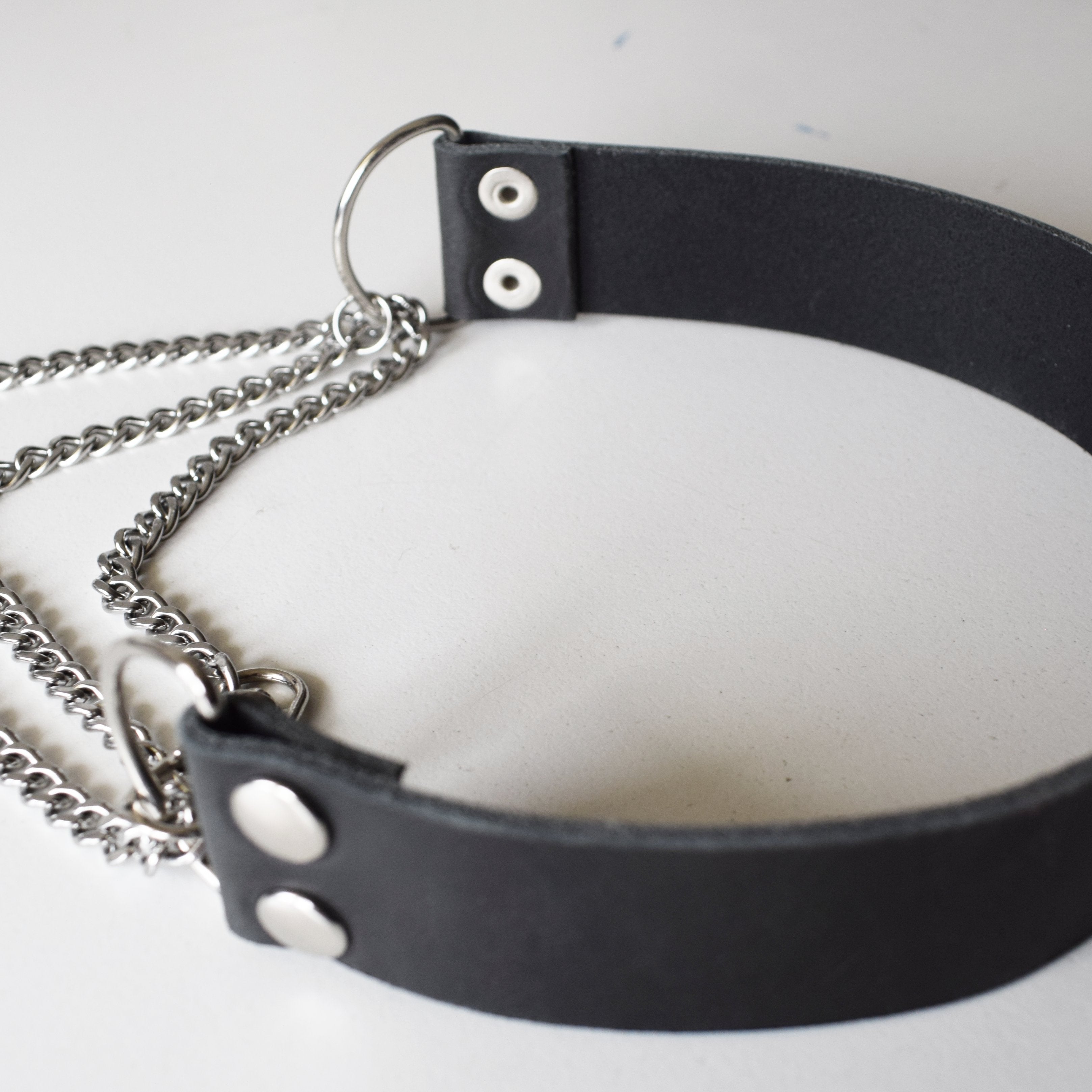 Black leather choker with silver chain on a white background