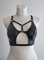Black cut-out wet look bra on a mannequin against a plain background