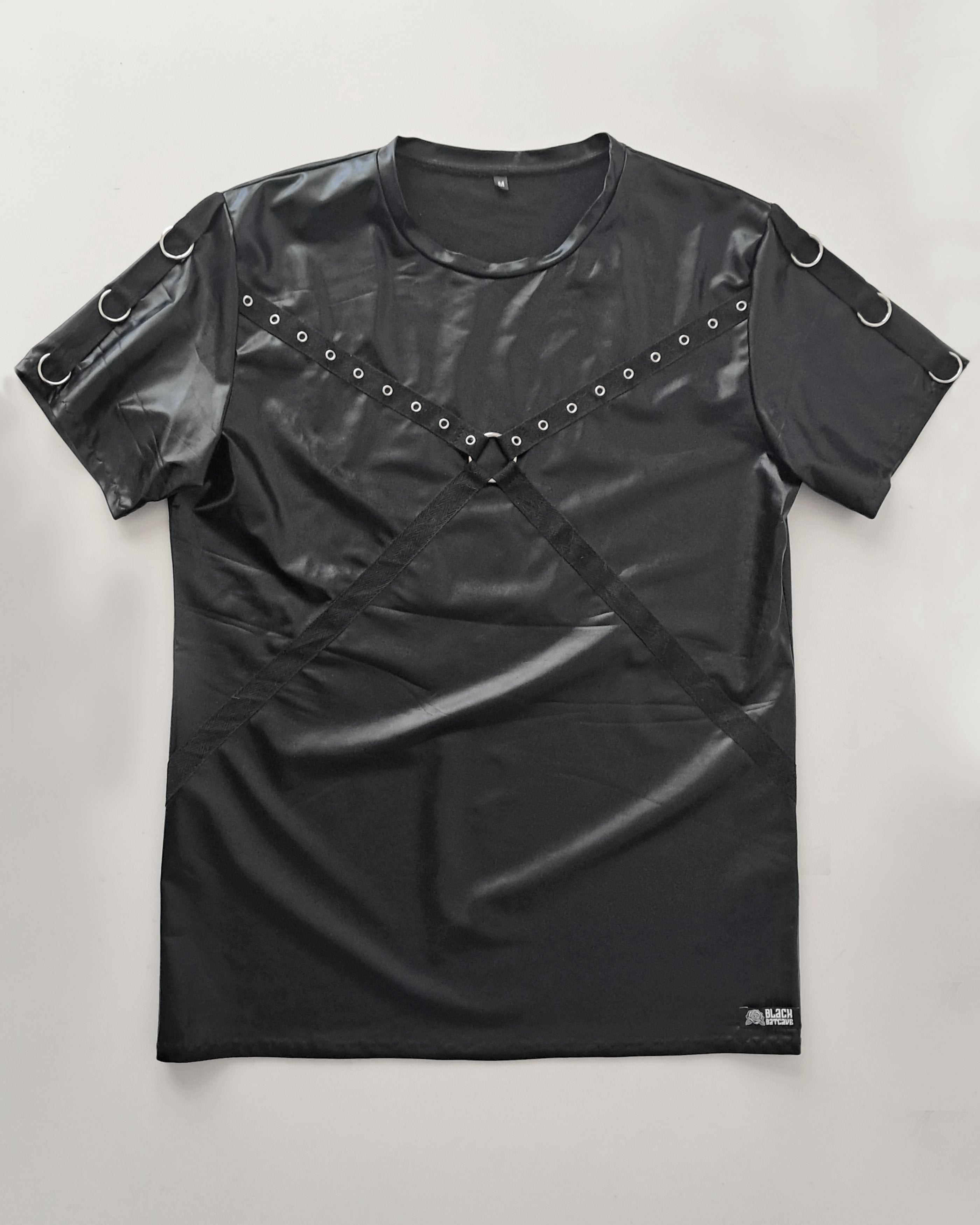 Black leather-like top with shoulder straps and studs on a light gray background