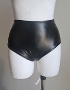 Black wet-look cut-out panties on a mannequin against a plain background