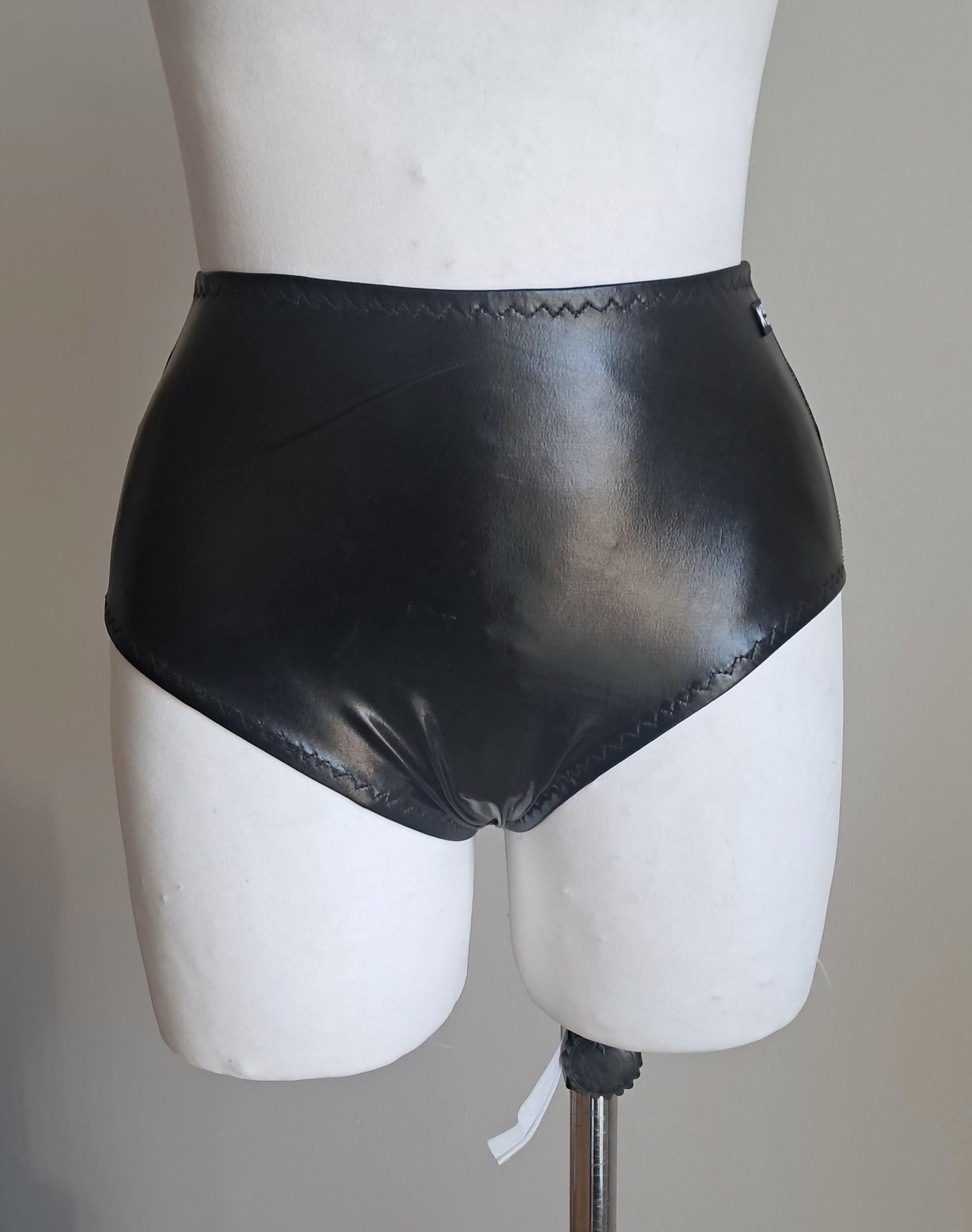 Black wet-look cut-out panties on a mannequin against a plain background