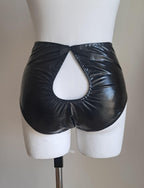 Black wet-look cut-out panties on a mannequin against a plain background