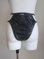 Black wet-look cut-out panties on a mannequin against a plain background