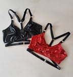 Black and red wet look wrap bras on a light gray background