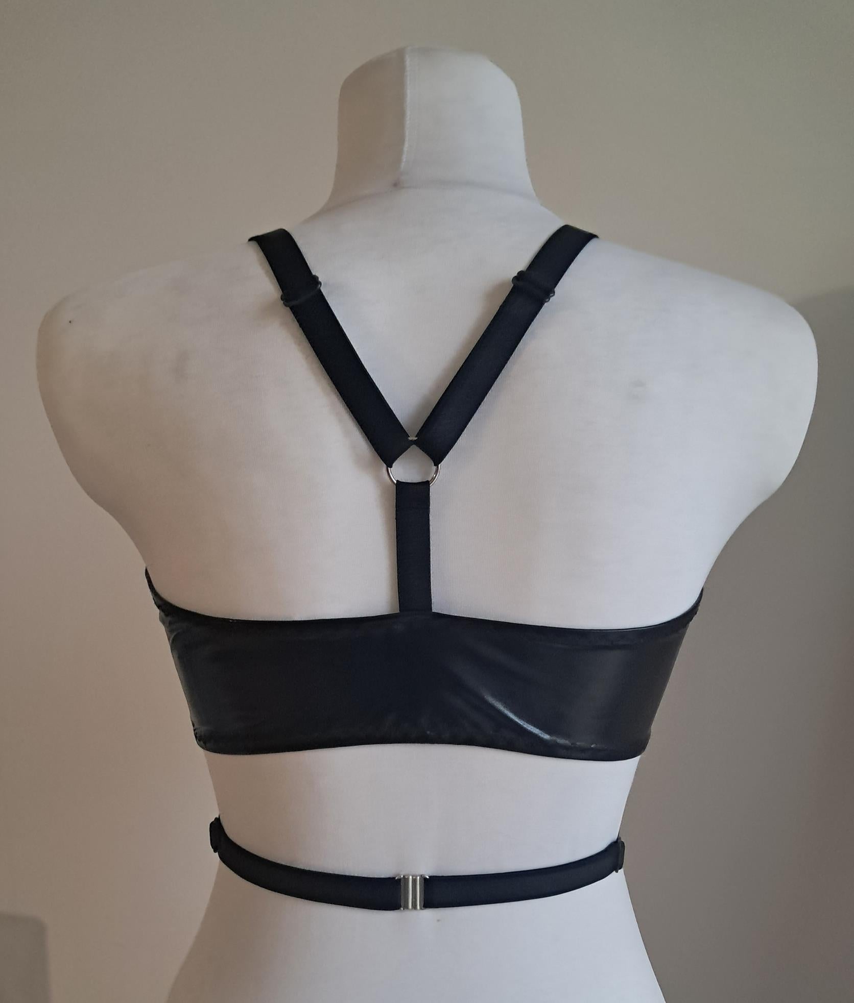 Black wet look wrap bra on a mannequin against a plain background