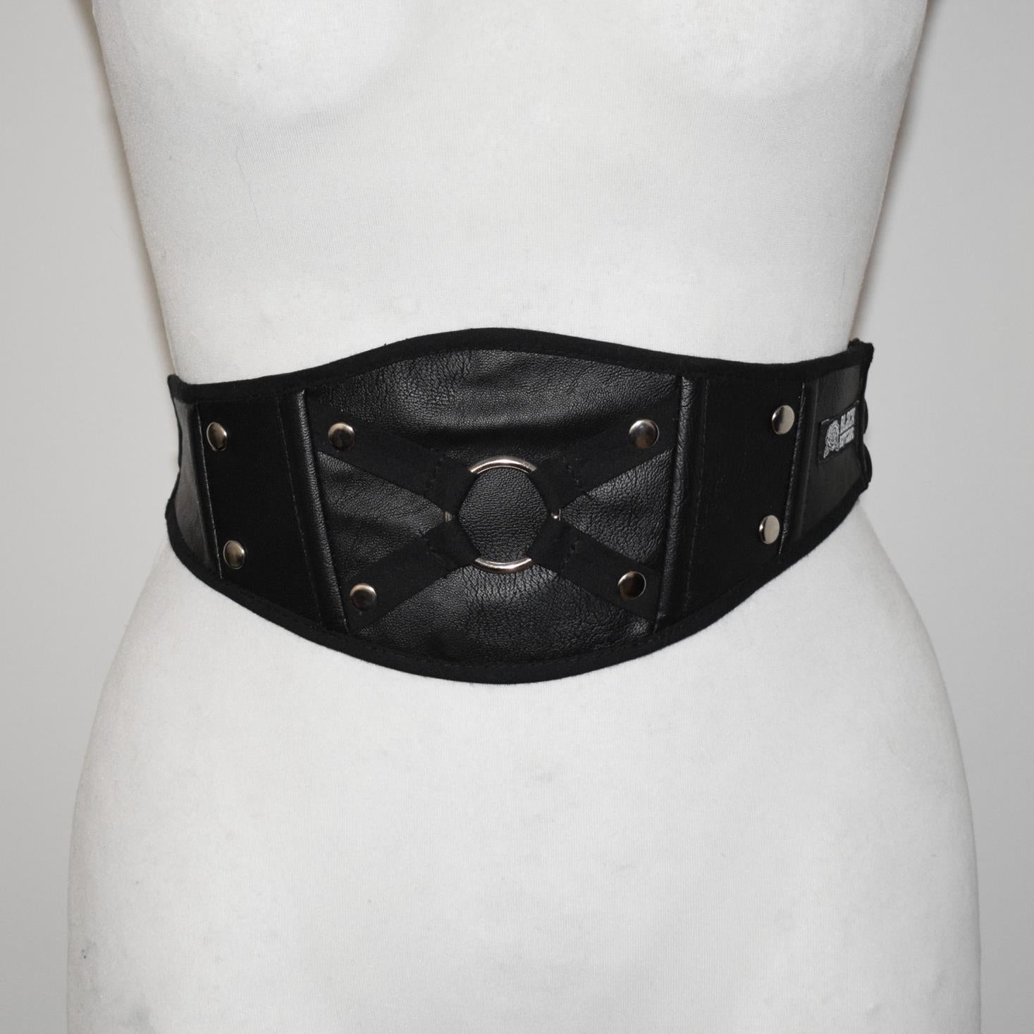 Black leather belt with metallic accents on a mannequin against a white background
