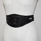 Black leather belt with gold accents on a mannequin against a white background