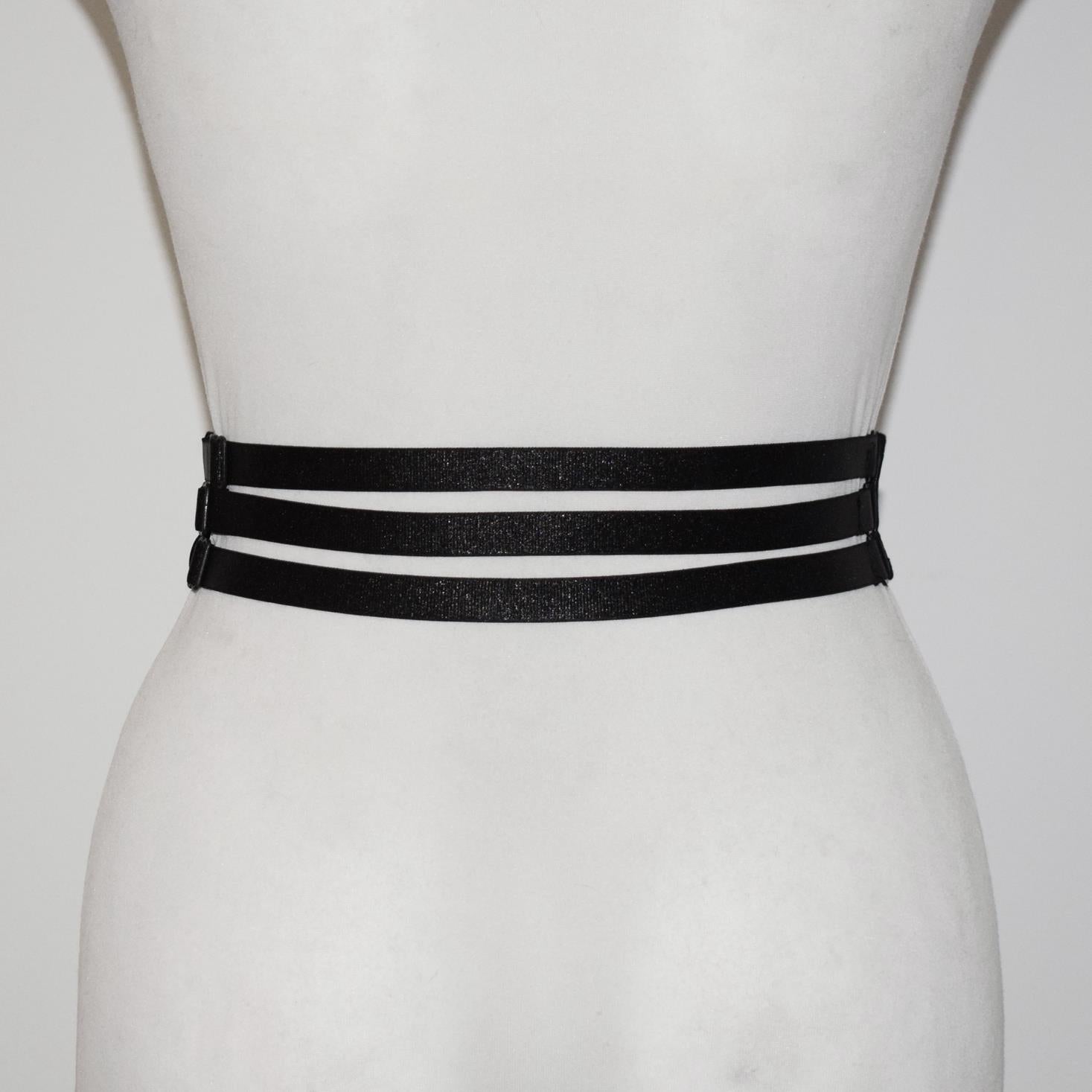 Black belt with three straps on a mannequin against a white background