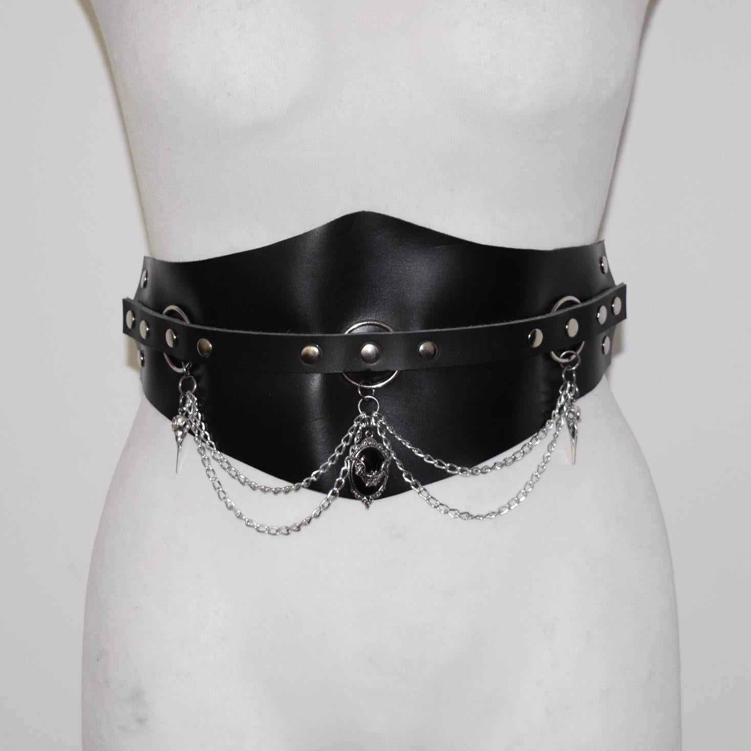 Black leather belt with chain details on a mannequin against a white background