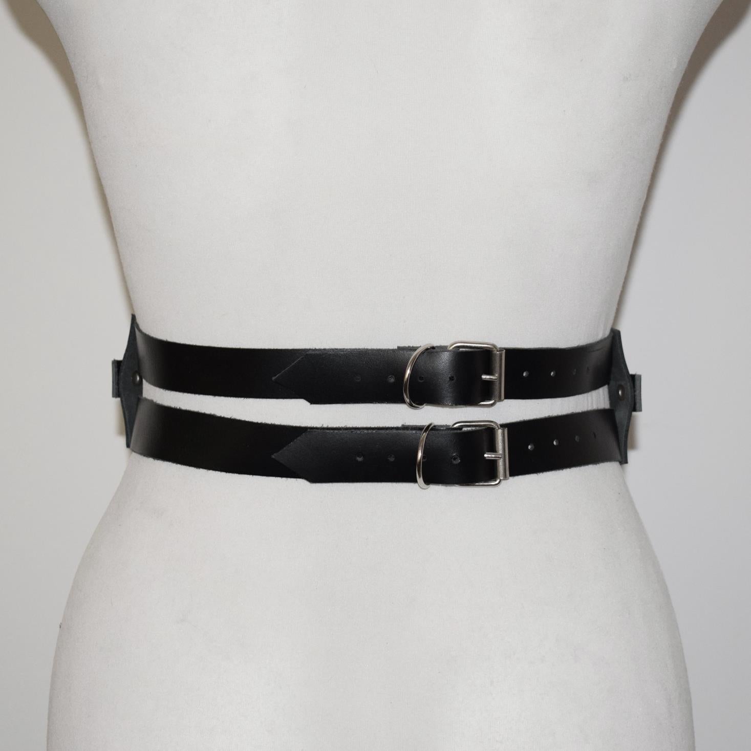 Black leather belt with silver buckles on a mannequin form against a white background