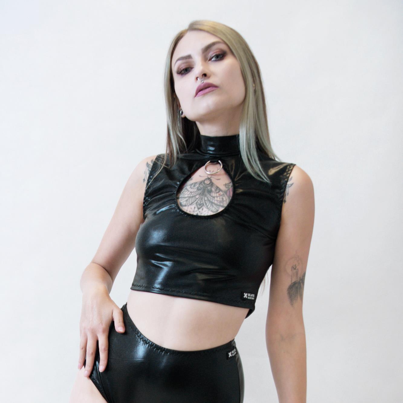 Person wearing a black wet-look sleeveless crop top with a white background