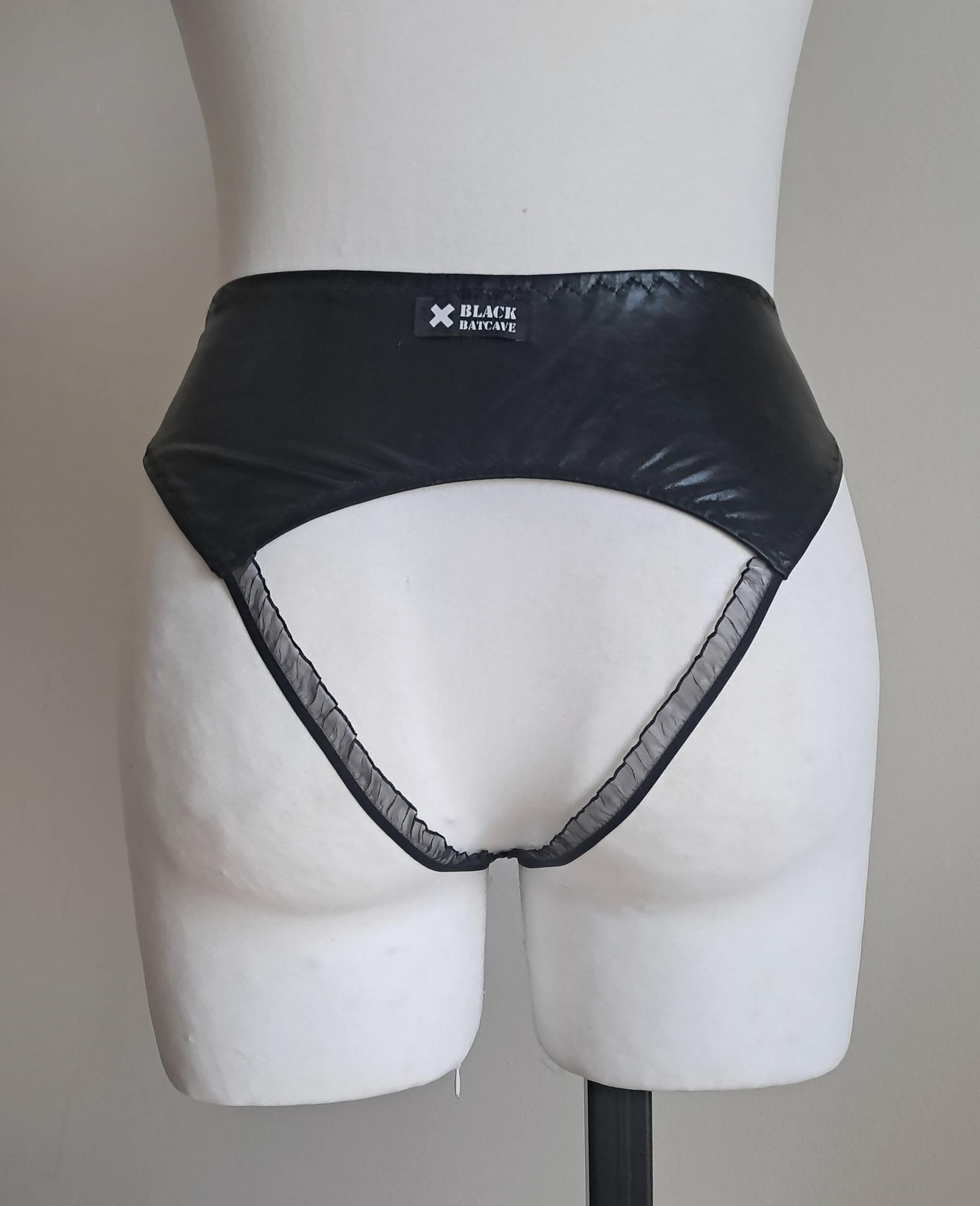 Black wet-look open crotch panties on a mannequin against a plain background