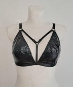 Black wet look triangle bra on a mannequin against a plain background