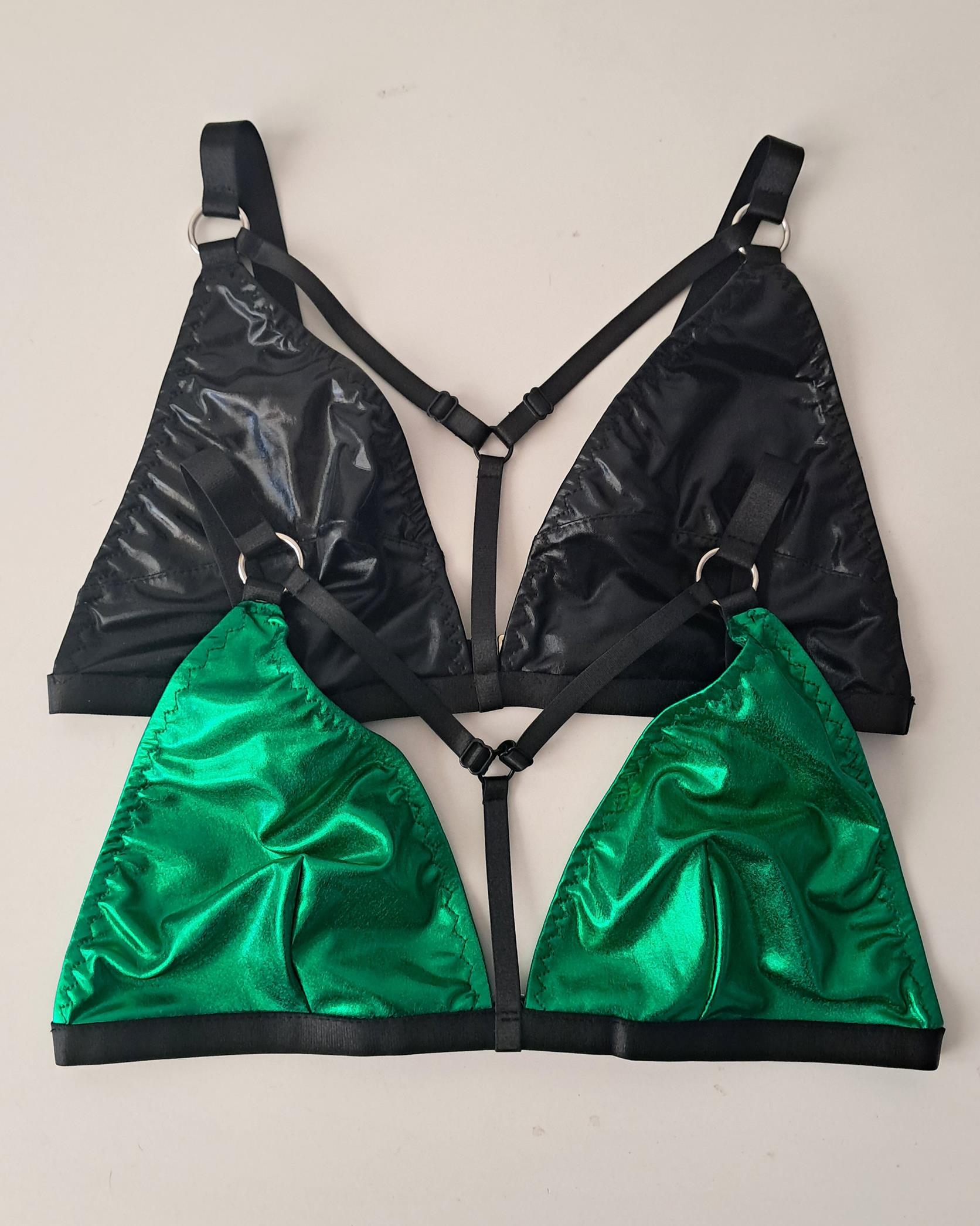 Black and green metallic wet look triangle bras on a light gray background