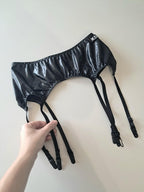 Black wet look garter belt with straps on a white background