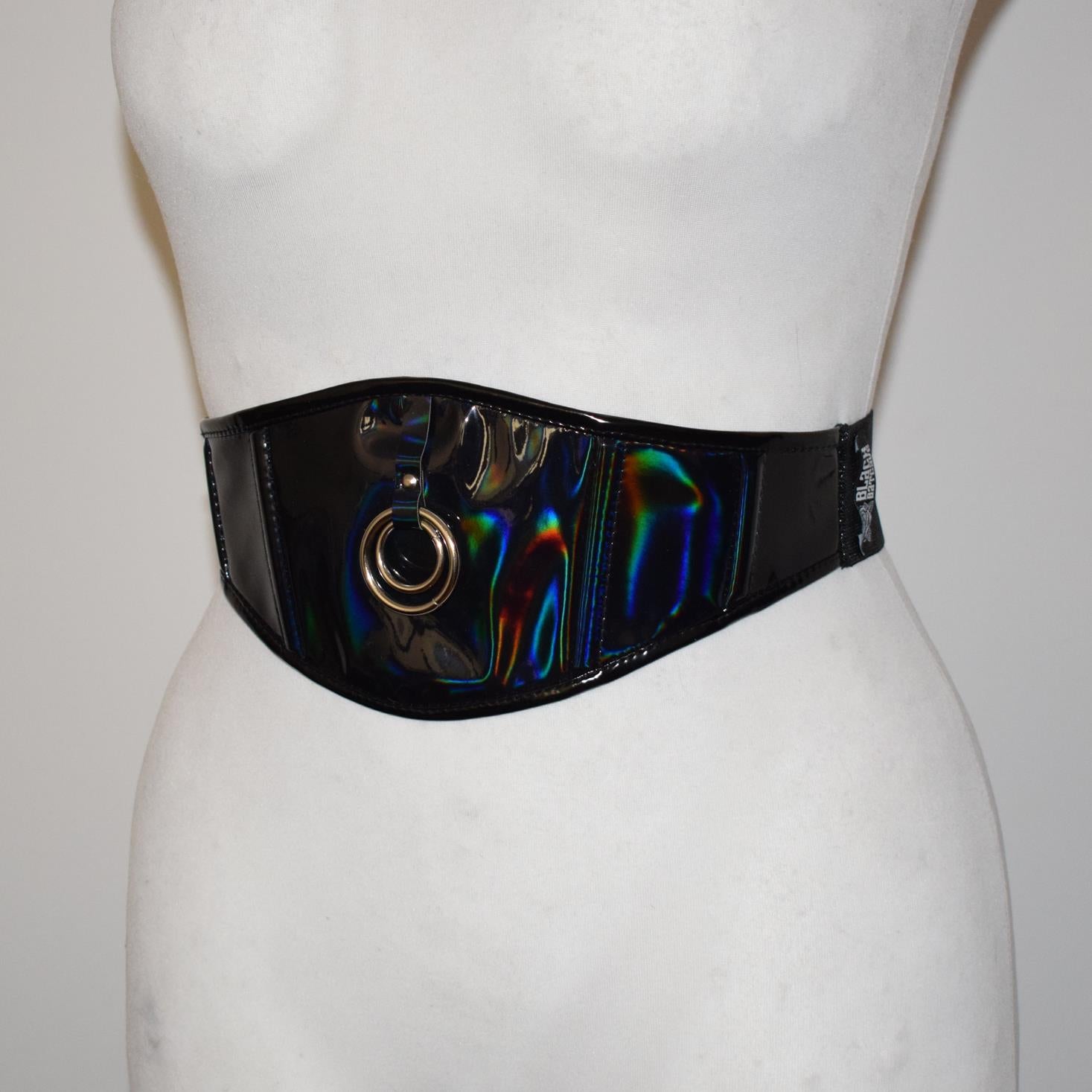 Mannequin wearing a wide, colorful belt with metallic accents on a plain background